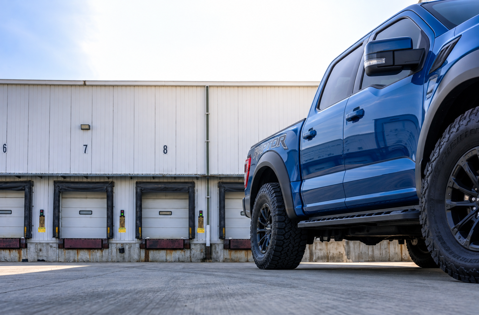 Blue pickup truck at a logistics loading facility